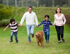 Family and dog running on grass