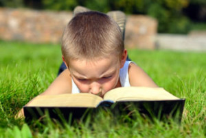 boy reading a book outdoors