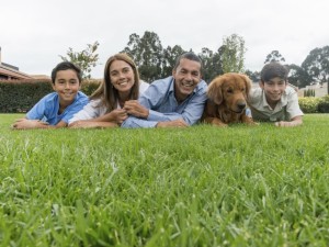 family with dog lying in grass