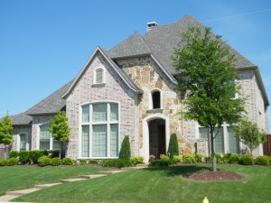 brick home with green yard and trees