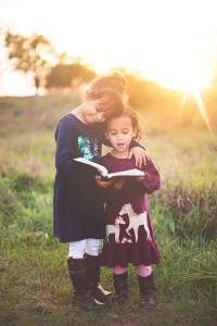 Two girls read outdoors