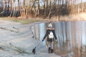 woman and dog walk in park winter 