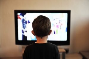 Child standing in front of TV screen