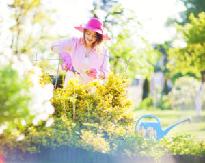 woman watering flowers in backyard