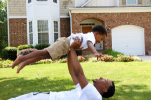 Father and his son playing outside in their yard