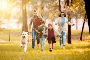 Family running in the fall with a dog